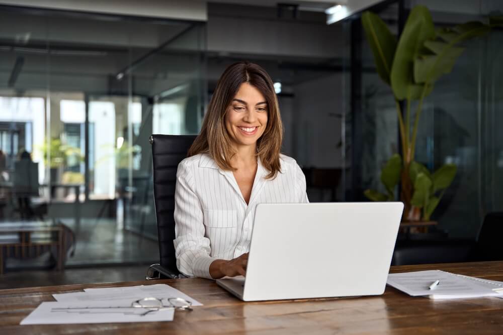 mulher mexendo no notebook, ambiente de escritório