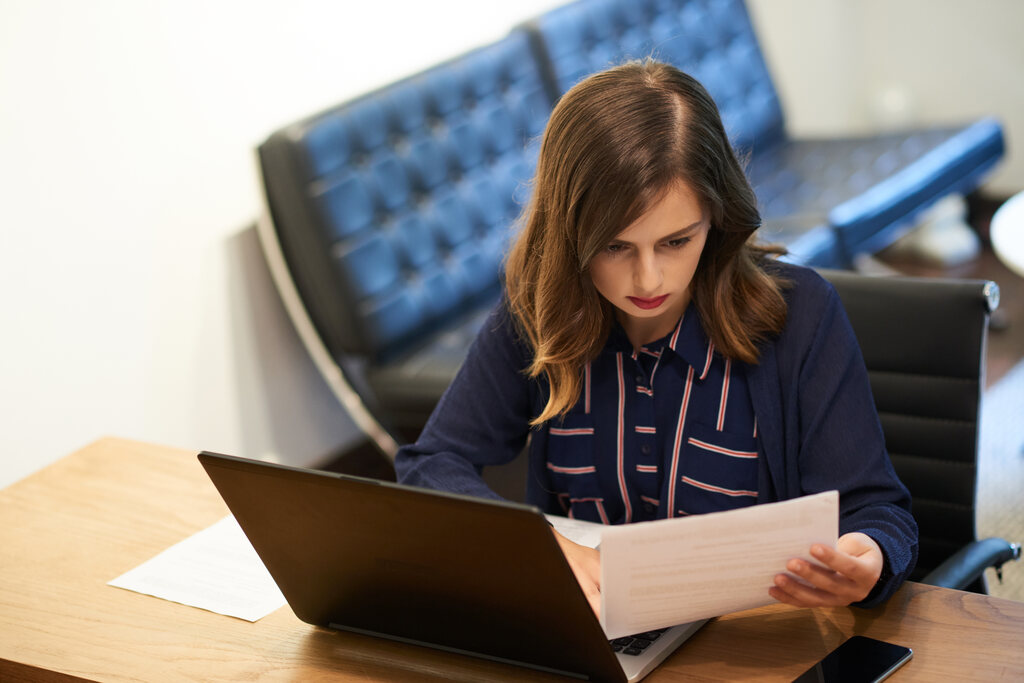 Mulher no Notebook anotando em documento como começar na advocacia