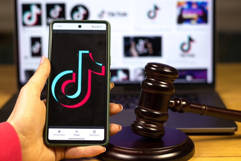 Celular com logo do tiktok e malhete atrás