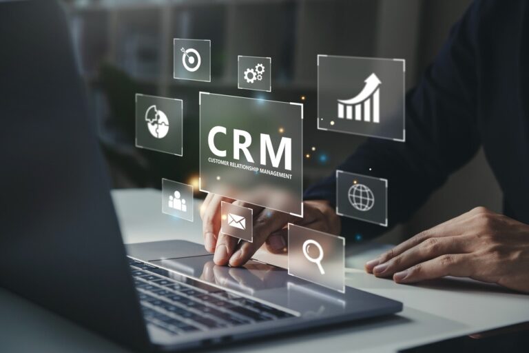 Homem mexendo em notebook com "CRM" escrito em cima