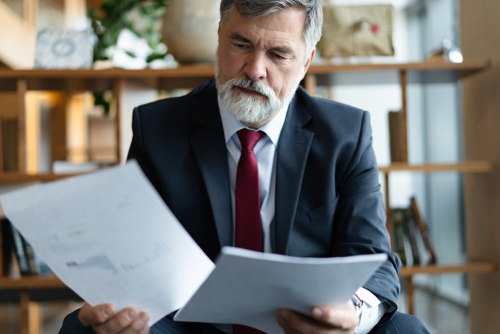 Homem com documento nas mãos sobre honorários contratuais