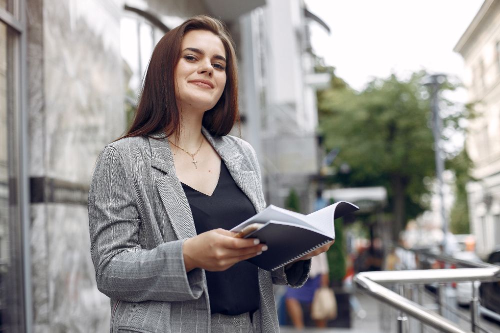 Advogada sorrindo com caderno na mão